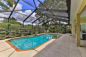 Enclosed pool area with lanai, outdoor seating/eating area and gas grill.
