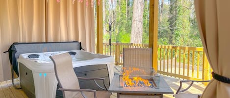 Enjoy a beautiful nature scenery while you relax in the brand new 4-5-person hot tub with 20 hydrotherapy jets, bench seating, furniture near a fire pit, and privacy curtains. 3 of 3 decks.
