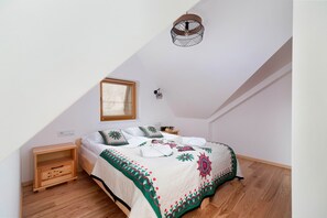 A cozy bedroom with a wooden bedframe and colorful bedding, perfect for a mountain retreat.
