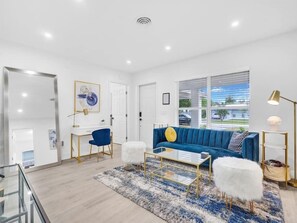 Gorgeous living room space with seating for six. Plush velvet couch and dedicated workspace.