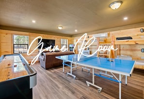The game room doubles as a cozy bunk room, complete with a massive TV and vintage arcade games for endless entertainment