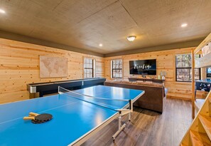 This recreation room is the ultimate hangout spot, perfect for both kids and adults to enjoy a variety of games and entertainment options.