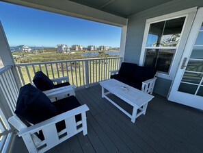 Porch off of the kitchen has plenty of seating to relax and watch the sunsets.