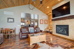 The spacious living room includes a large tv and gas fireplace. 