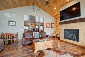 The spacious living room includes a large tv and gas fireplace.