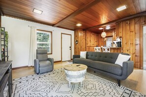 Warm living room with rustic wood paneling.
