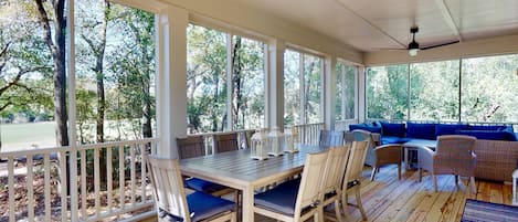 Stretch out in privacy on the back screened in deck with plenty of seating for relaxing on the couch or enjoying a meal at the table