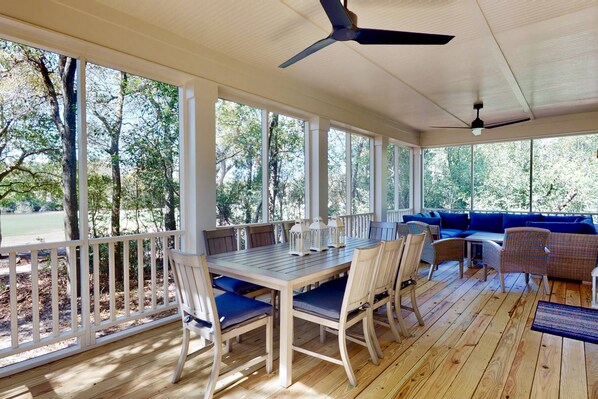 Stretch out in privacy on the back screened in deck with plenty of seating for relaxing on the couch or enjoying a meal at the table