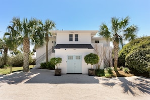 Sunshine by the Sea framed by a beautiful blue sky and palmetto trees!