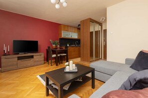 Another angle of the living room featuring a flat-screen TV and spacious layout.
