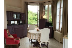 Trois grandes fenêtres donnant sur le parc, et l'entrée du parc Napoléon III