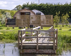 Only two pods on the site, overlooking a picturesque pond with a bridge.