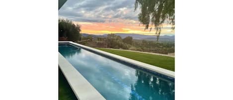 55' lap pool with sunset view.  Pink moment view through the house from pool