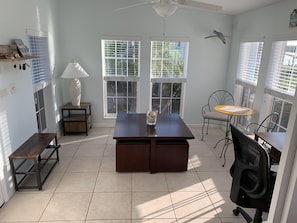 Sunroom has a gaming table, desk, and best views in the house.