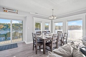 Dining room seating for 8 with lakes views framed by floor-to-ceiling windows.