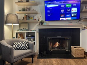 Wood burning fireplace and record player in downstairs living room.  Roku TV.