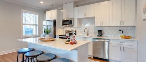 Fully equipped kitchen boasting stainless-steel appliances and stocked with all culinary essential for your convenience.