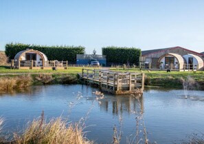 Both pods with parking and a view of the pond with bridge.