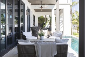 Patio seating - Looking to east on front porch of seating area, pool, and outdoor cooking area in the back.