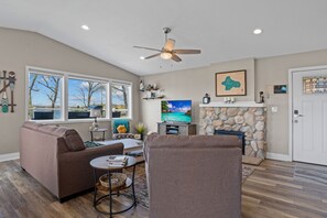 Open concept living room with sleeper sofa, smart TV and gas fireplace 