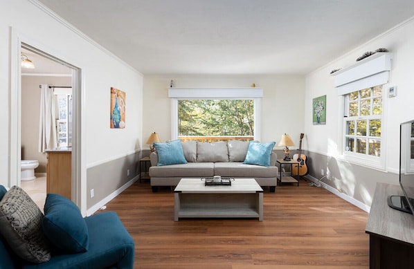 Light, bright and airy living room with huge windows looking out to nature