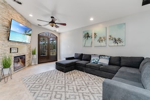 Spacious gray couch, large TV, perfect for relaxing with loved ones.