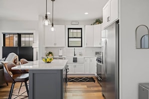Beautiful, fully-equipped kitchen with spacious island for prepping, a toaster oven, Keurig, and frother.