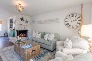 The living room has an open gas fireplace that provides great heating and ambiance.