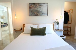 Drift off in a bright and serene bedroom with plush white bedding and calming decor.