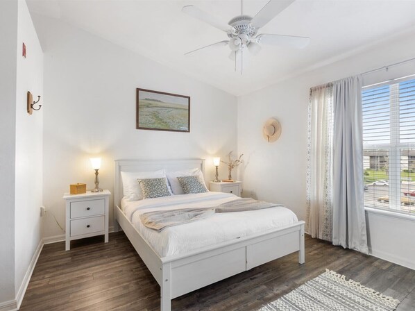 Bright and airy bedroom with cozy bedding, blackout curtains, and plenty of natural light—perfect for a restful night’s sleep.
