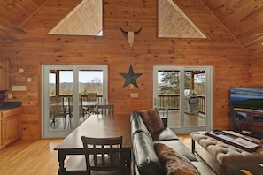 A-Frame Living Room, Dining Area, & Kitchen with sliding deck doors to the deck