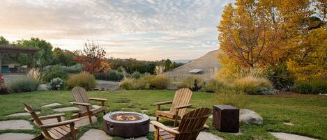 Watch the sunset by the cozy fire pit and expansive private backyard.
