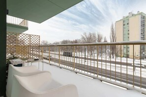 A balcony overlooking the surrounding neighborhood with a snowy urban view.
