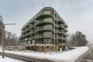 Exterior view of a uniquely designed green building in a snowy landscape.
