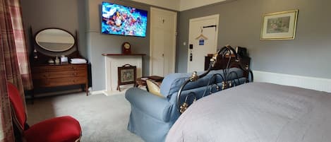 Ivystone with large TV on wall, and sofa in front