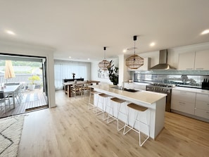 Open plan kitchen, dining room opening onto al fresco area