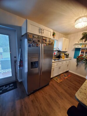 Kitchen and door to outside deck and fully fenced backyard. 
