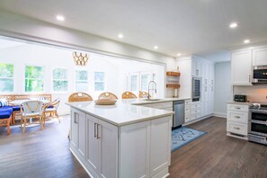 The spacious, renovated kitchen opens into a dining area with banquette seating.