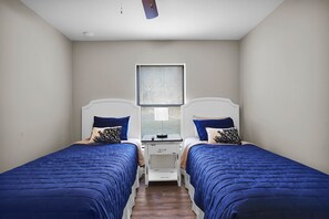 Modern twin bedroom with two single beds and minimalist decor.