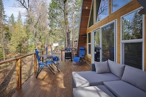 Back deck with outdoor furniture and grill to relax and enjoy the woodsy nature