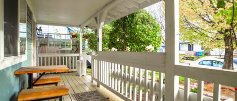 Wraparound porch, with view of breakfast table. To the right is the street.
