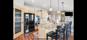 Kitchen with island.  Island has 4 bar chairs.