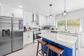 Kitchen with island seating exudes a bright and cheery ambiance, inviting both meal preparation and lively conversations.