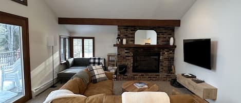 Upper living room with wood burning fireplace.