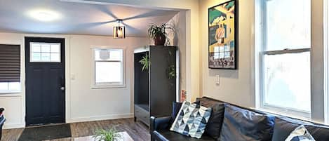 Open concept living room with rustic, exposed beams that showcase the upper half story loft space.