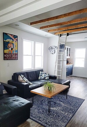 Open concept living room with high ceilings through the rustic exposed beams.