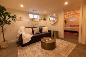 A comfortable leather couch with a golden drum coffee table