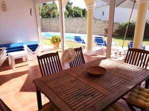 Outside dining patio with sun terrace and view of private pool 