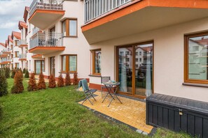 An exterior view of a charming building with a well-maintained garden and outdoor seating area.
