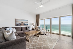 Living Room | Take it Breezy| Breathe Easy Rentals - Plenty of room for all to crash, enjoy the view and just relax. L-shaped sofa, club chair with ottoman,
and ceiling fan to keep it breezy. Don't forget that magnificent gulf view!